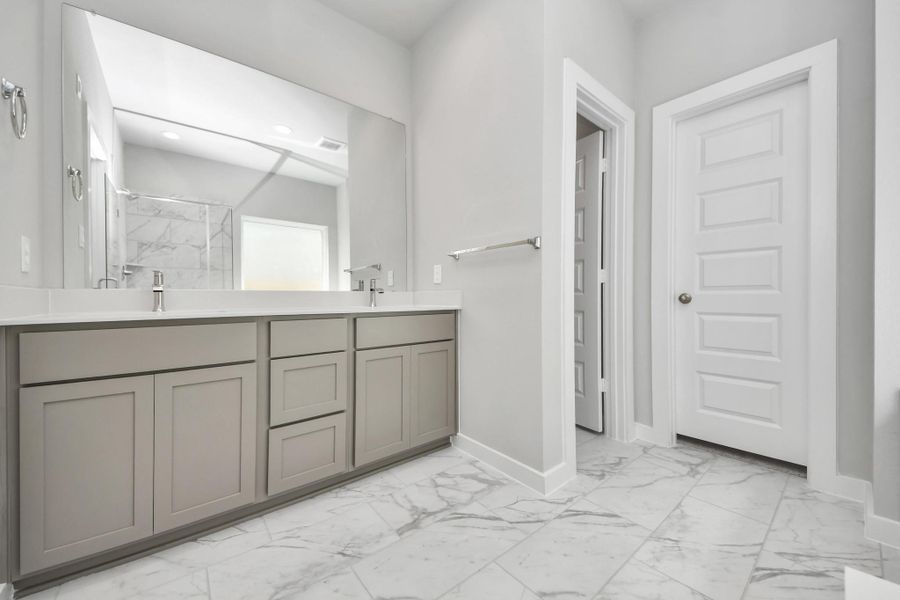 Escape to a spa-like oasis in this primary bathroom. Enjoy a walk-in shower with tile surround, a separate garden tub with custom detailing, and an elegant vanity featuring light countertops, modern hardware, and beautiful vanity lights. Experience luxury and relaxation in every detail. Sample photo of completed home with similar floor plan. Actual colors and selections may vary. Escape to a spa-like oasis in this primary bathroom. Enjoy a walk-in shower with tile surround, a separate garden tub with custom detailing, and an elegant vanity featuring light countertops, modern hardware, and beautiful vanity lights. Experience luxury and relaxation in every detail. Sample photo of completed home with similar floor plan. Actual colors and selections may vary.