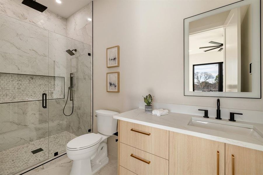 Bathroom featuring vanity, toilet, and an enclosed shower