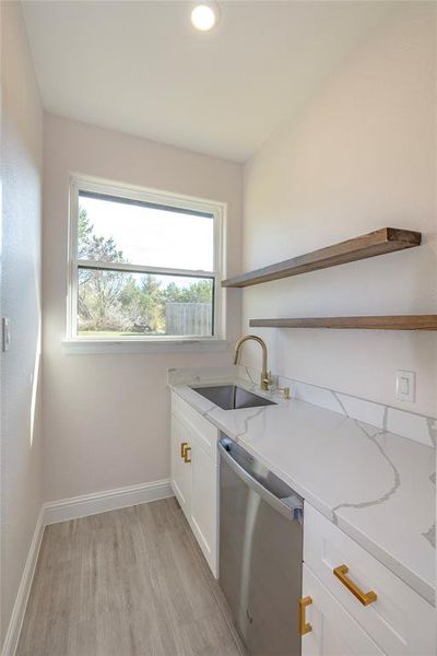 Laundry room with light wood-type flooring and sink