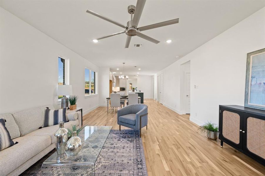 Living room featuring light wood-style floors, ceiling fan, and recessed lighting