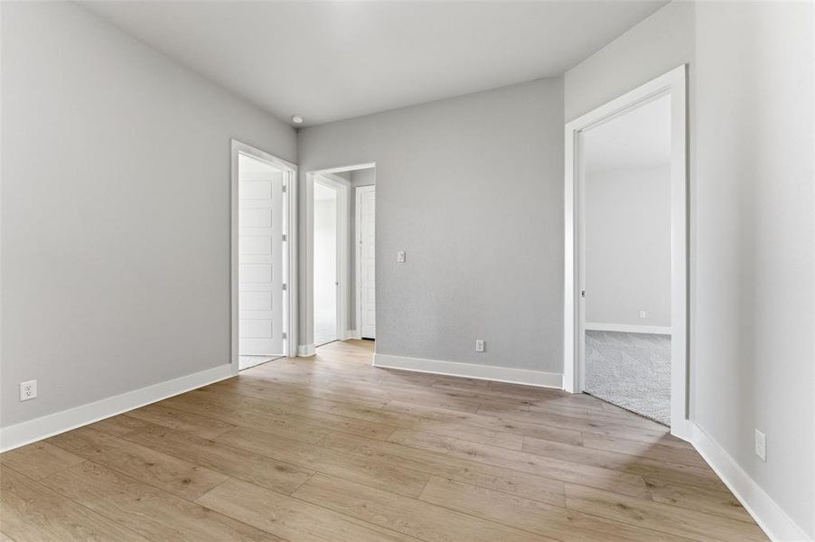 Unfurnished bedroom featuring light wood finished floors and baseboards