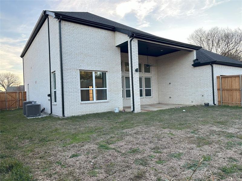 Back of property featuring a patio, a lawn, and central air condition unit