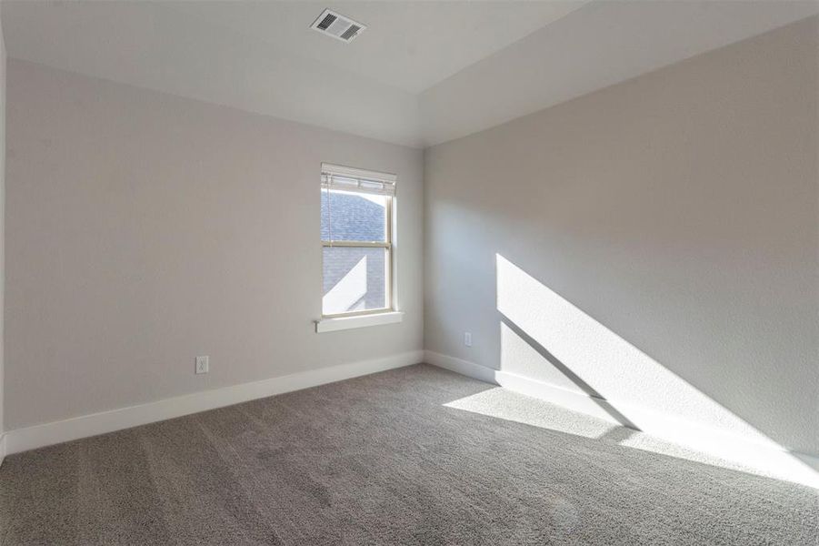 Spare room featuring carpet floors and lofted ceiling