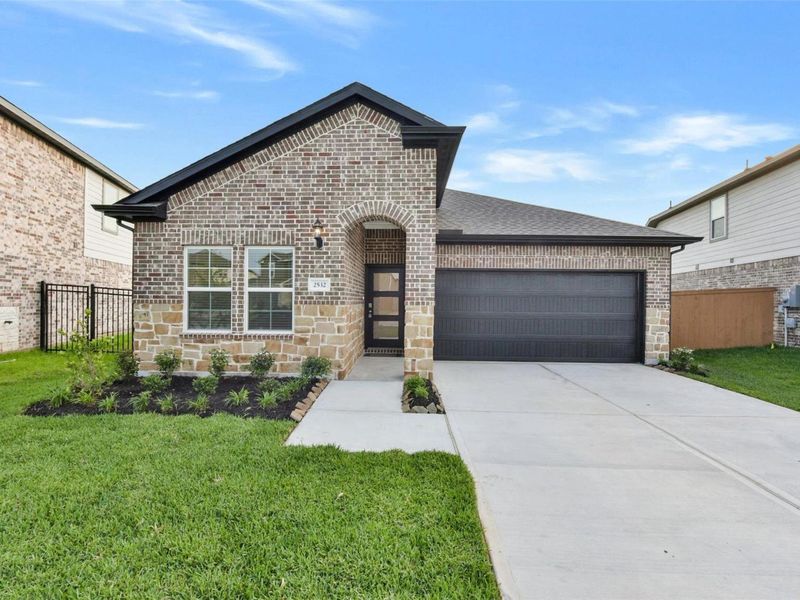 Front exterior of a new home in Sunterra, Katy, TX, highlighting curb appeal (Image 2).