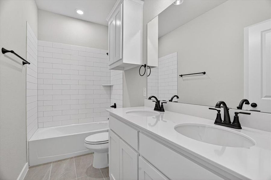 Bathroom featuring a dual-sink vanity with white countertops, matte black fixtures, a built-in tub with subway tile surround, recessed lighting, and wood-finish flooring