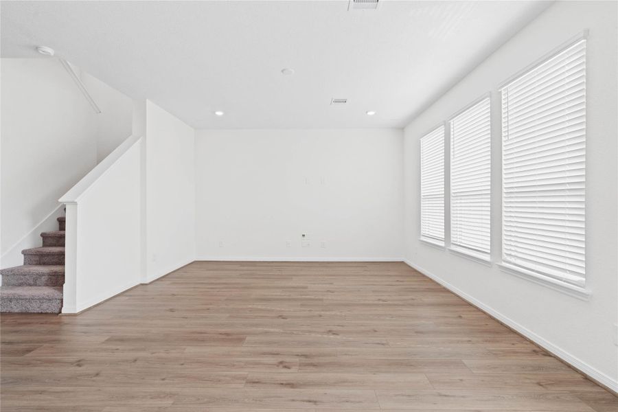 This bright and airy Great Room offers a spacious layout ideal for both relaxing evenings and lively gatherings. Designed for comfort and connection, it features Layton Lake vinyl plank flooring in Wild Dunes, large windows with blinds, high ceilings, recessed lighting, and seamless access to the stunning kitchen and dining—perfect for everyday living and entertaining alike. This bright and airy Great Room offers a spacious layout ideal for both relaxing evenings and lively gatherings. Designed for comfort and connection, it features Layton Lake vinyl plank flooring in Wild Dunes, large windows with blinds, high ceilings, recessed lighting, and seamless access to the stunning kitchen and dining—perfect for everyday living and entertaining alike.