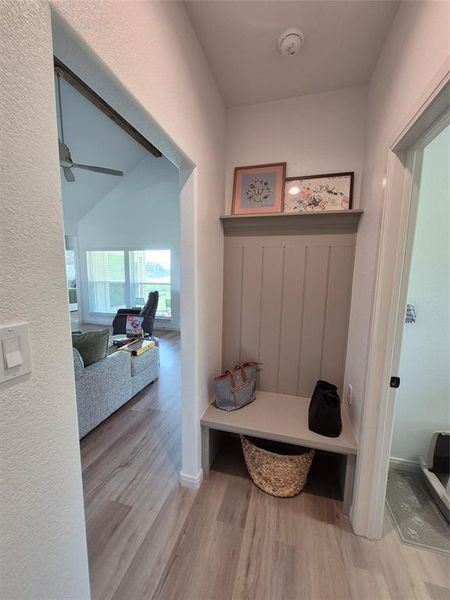 Mudroom featuring light wood-style floors and a textured wall