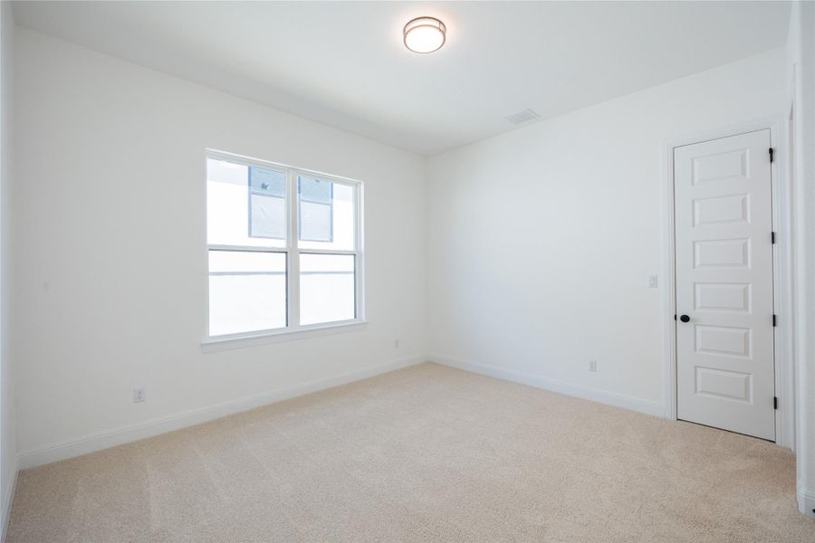 Spare room with light colored carpet and baseboards