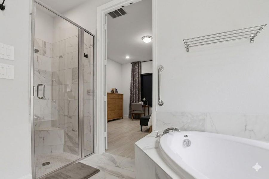 A full-view of the walk-in shower highlighting the floor-to-ceiling tile work and clear glass enclosure.