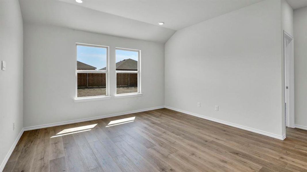 Empty room with lofted ceiling, light wood-type flooring, and recessed lighting