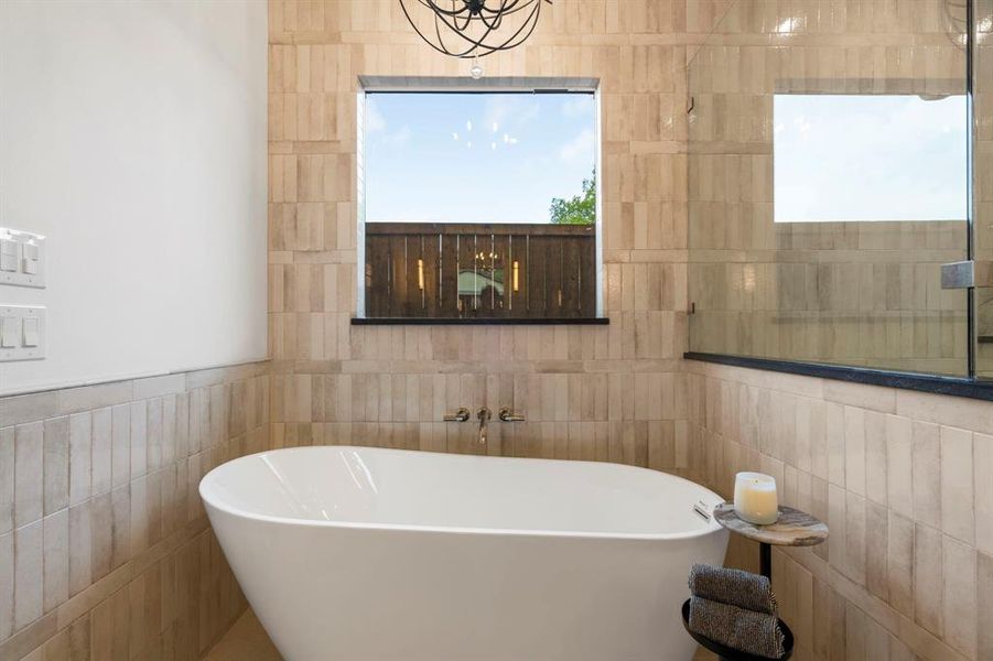 Full bath featuring tile walls and a freestanding tub Full bath featuring tile walls and a freestanding tub