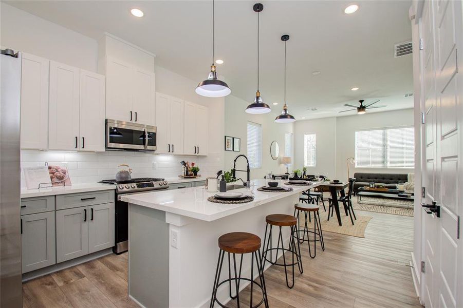 This attractive Kitchen is full of beautiful details. Quartz Countertops, Stainless Sink, Stainless Steel Appliances, Recessed Lighting and pendant lights, Undercabinet Lighting, Elegant Cabinetry with Soft Close Drawers and Doors. UNDER CONSTRUCTION!!  Photos from another community's model home FINISHES & COLORS MAY VARY! Ceiling fans are not included!