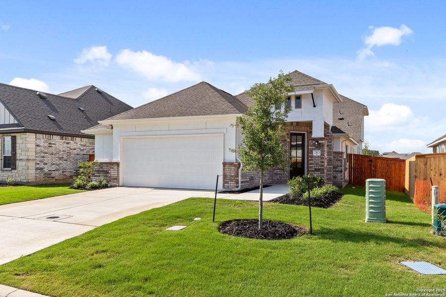 Front exterior of a new home in Megan's Landing, Castroville, TX, highlighting curb appeal (Image 21).