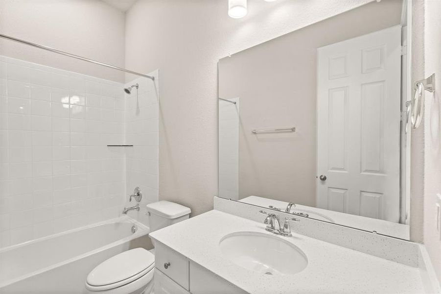 The secondary bath features tile flooring, white cabinetry and light countertops and a shower/tub combo. Perfect for accommodating any visiting family and friends.