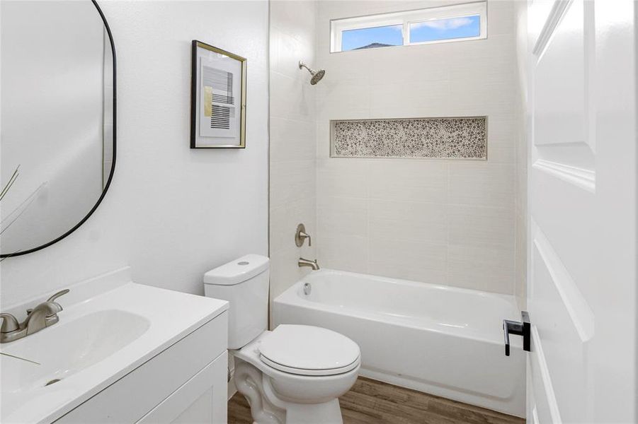 Bathroom featuring vanity, tub / shower combination, and wood finished floors Bathroom featuring vanity, tub / shower combination, and wood finished floors