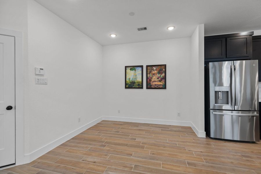 Closer up view of the dining area and refrigerator that is included.