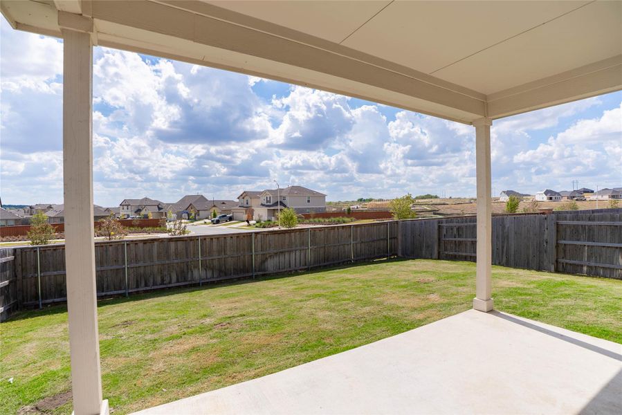 Fenced backyard featuring a residential view and a patio Fenced backyard featuring a residential view and a patio