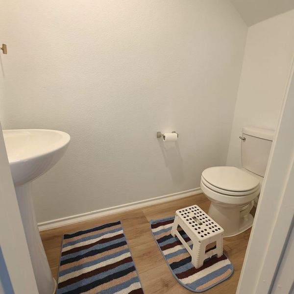 Half bathroom with baseboards and wood finished floors Half bathroom with baseboards and wood finished floors