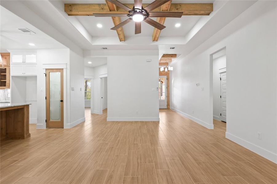 Unfurnished living room with beam ceiling, light wood-style flooring, ceiling fan, and recessed lighting