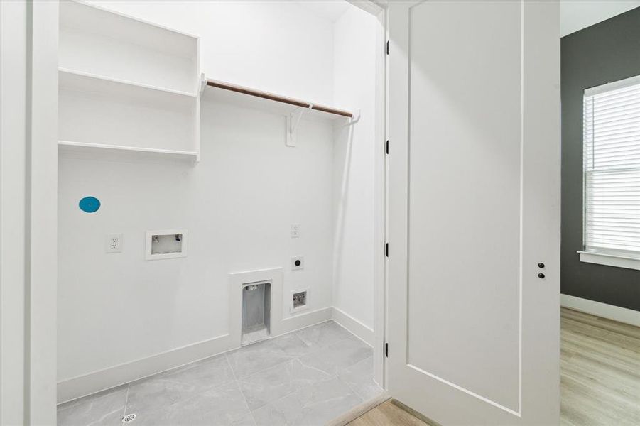 The well-designed utility room features both gas and electric hookups, making it compatible with any washer/dryer system. It also offers additional hanging and shelving space for added convenience and organization.