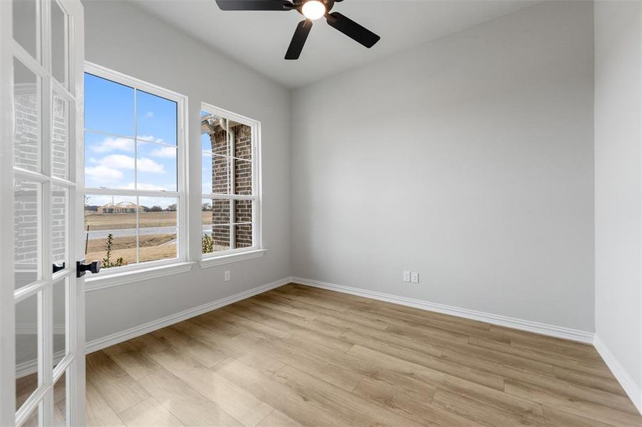 Empty room featuring light wood finished floors and a ceiling fan Empty room featuring light wood finished floors and a ceiling fan