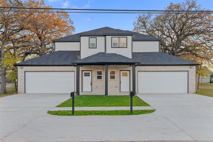 View of front of home with a garage and a front lawn