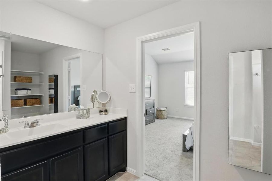 Bathroom with vanity, baseboards, and visible vents