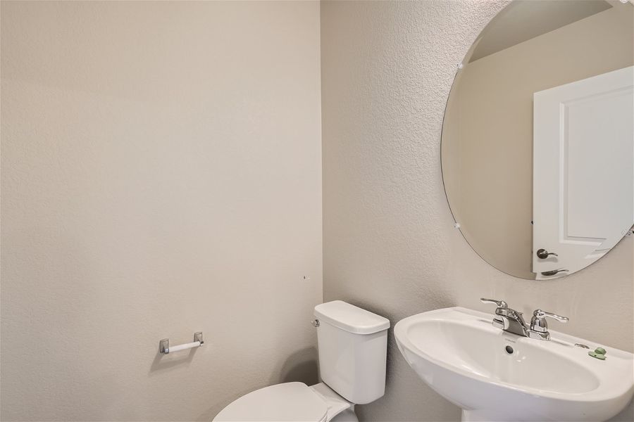 A bathroom with a round mirror.