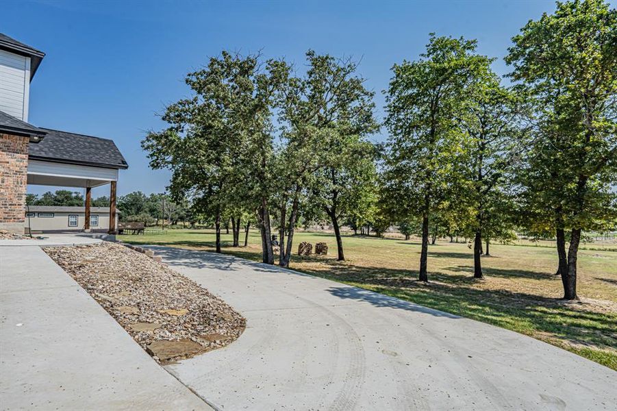 View of property's community featuring a lawn, concrete driveway, and a porch View of property's community featuring a lawn, concrete driveway, and a porch
