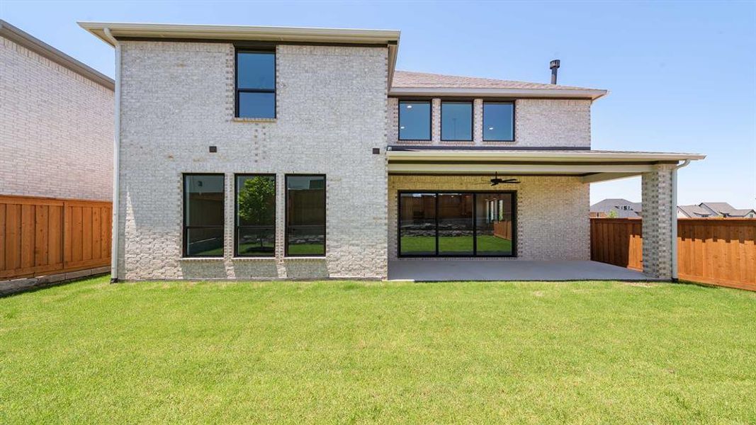 Rear view of property with a patio area, a fenced backyard, brick siding, and ceiling fan