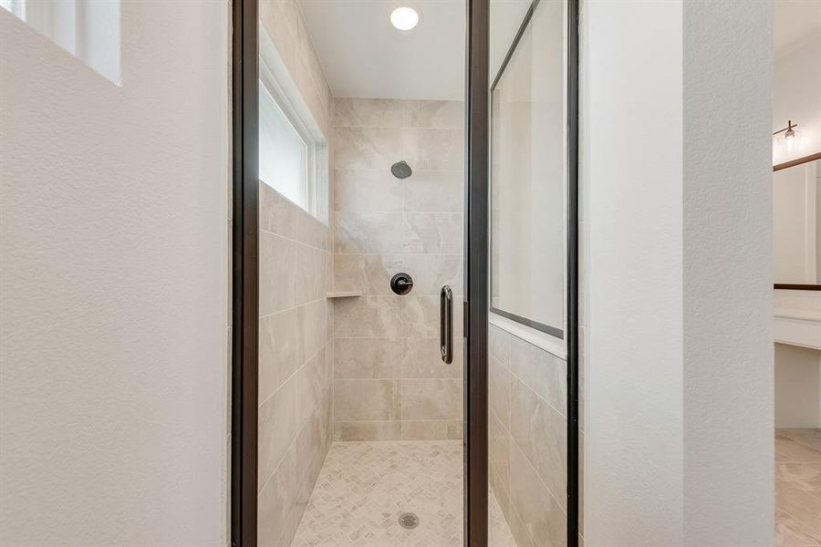 Bathroom featuring a shower stall, a textured wall, and recessed lighting Bathroom featuring a shower stall, a textured wall, and recessed lighting