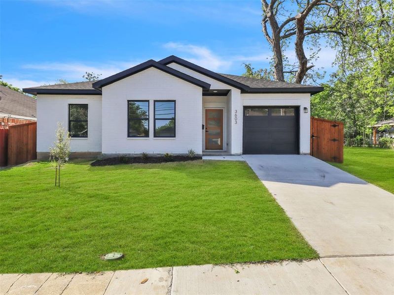 View of front of property featuring fence, a shingled roof, a front lawn, driveway, and a garage View of front of property featuring fence, a shingled roof, a front lawn, driveway, and a garage