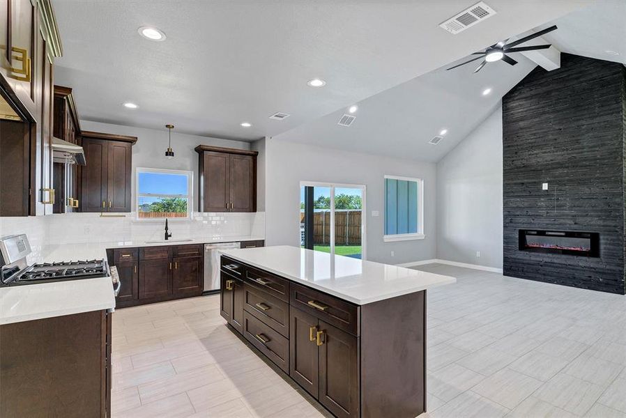 Kitchen featuring dishwasher, pendant lighting, vaulted ceiling with beams, and plenty of natural light