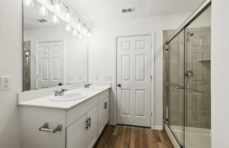 Spacious owner's bathroom with dual vanity and oversized shower *real home pictured