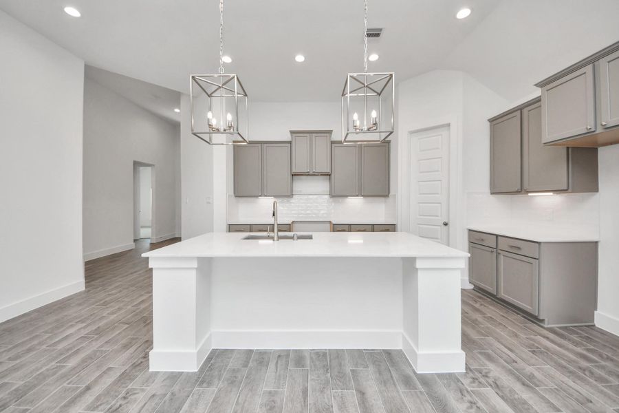 This kitchen is by far any chef’s dream! This spacious kitchen features high ceilings, light stained wood cabinets, granite countertop, SS appliances, modern tile backsplash, recessed lighting, extended counter space, granite kitchen island, and space for breakfast bar, and a walk-in pantry all overlooking your huge family room.