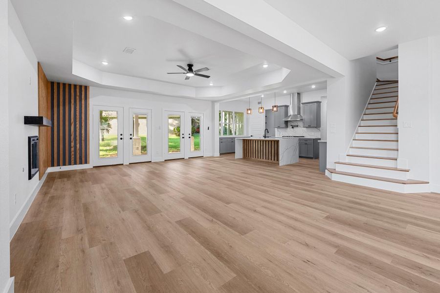 Elegant dining and living area seamlessly connects to a modern open kitchen, featuring a stylish tray ceiling accent. Elegant dining and living area seamlessly connects to a modern open kitchen, featuring a stylish tray ceiling accent.