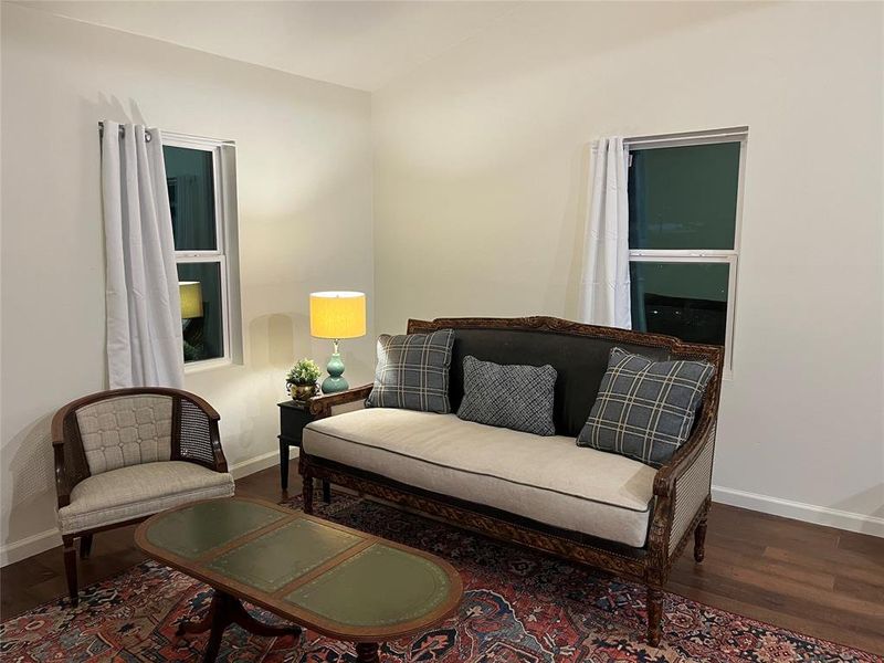Bright interior space featuring wood-finish flooring and two sash windows