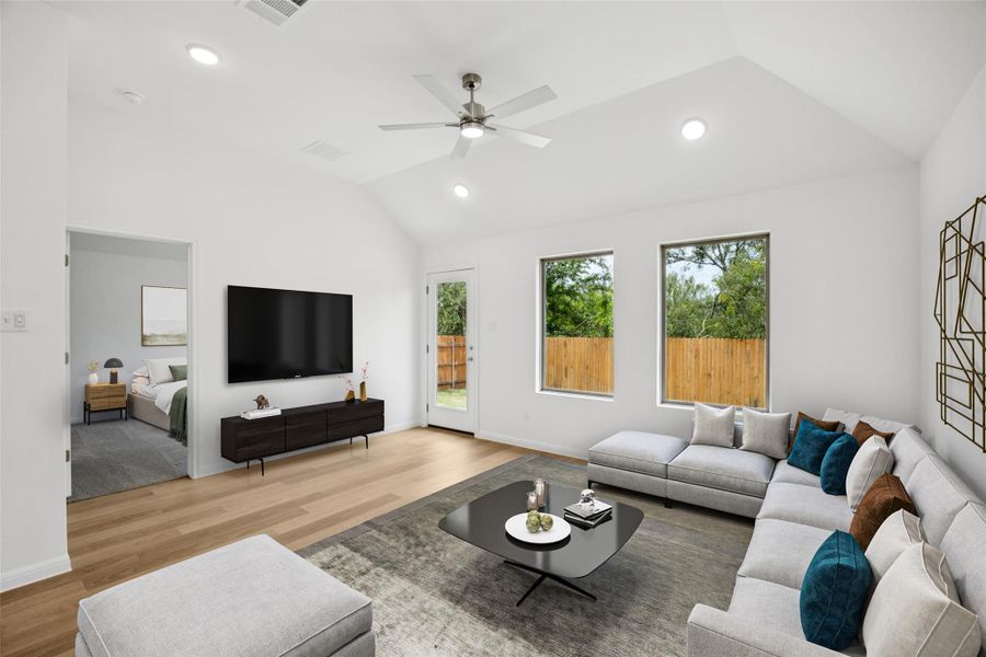 Living area featuring vaulted ceiling, light wood-style floors, recessed lighting, and a ceiling fan Living area featuring vaulted ceiling, light wood-style floors, recessed lighting, and a ceiling fan