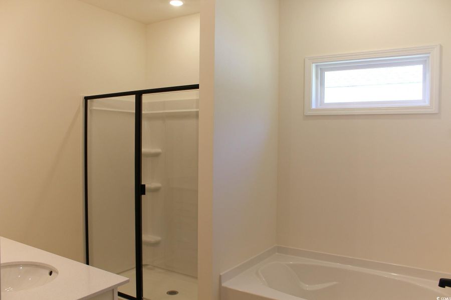 Full bath with a garden tub, vanity, and a stall shower Full bath with a garden tub, vanity, and a stall shower