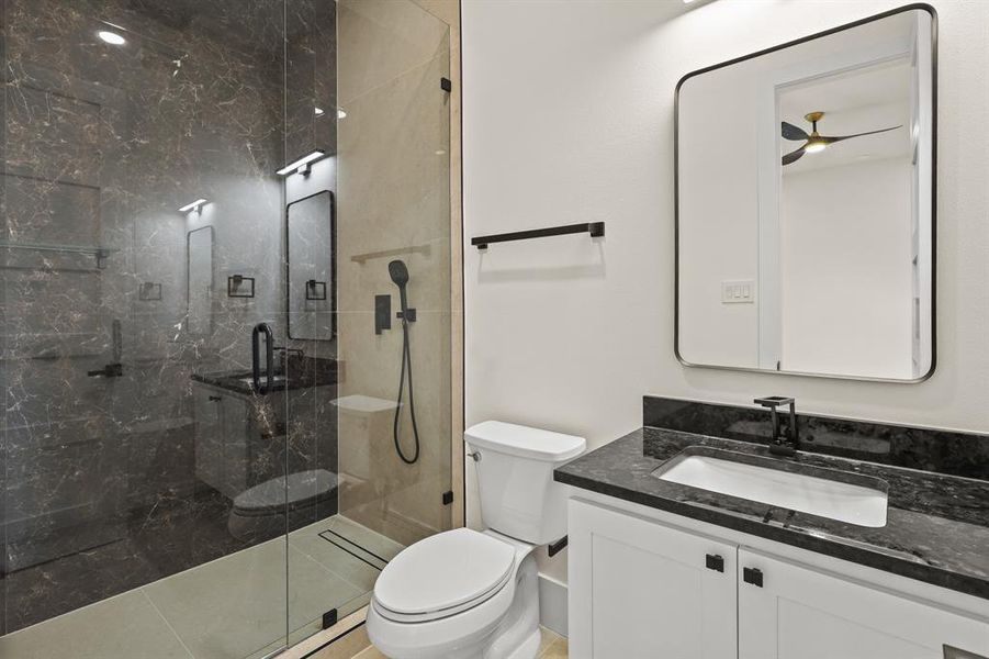 Bathroom with walk in shower, vanity, and toilet