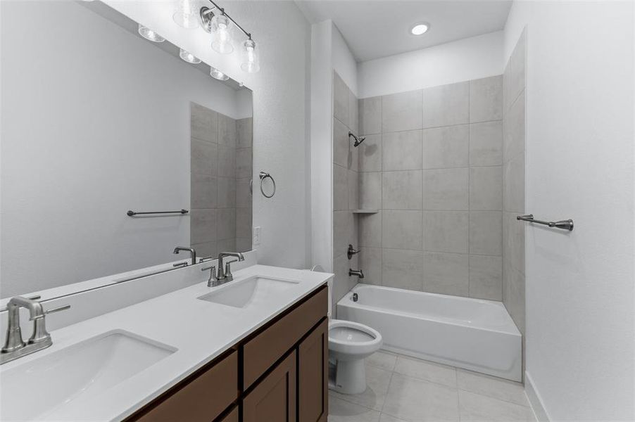 Full bath featuring double vanity,  shower combination, light tile patterned floors, and recessed lighting