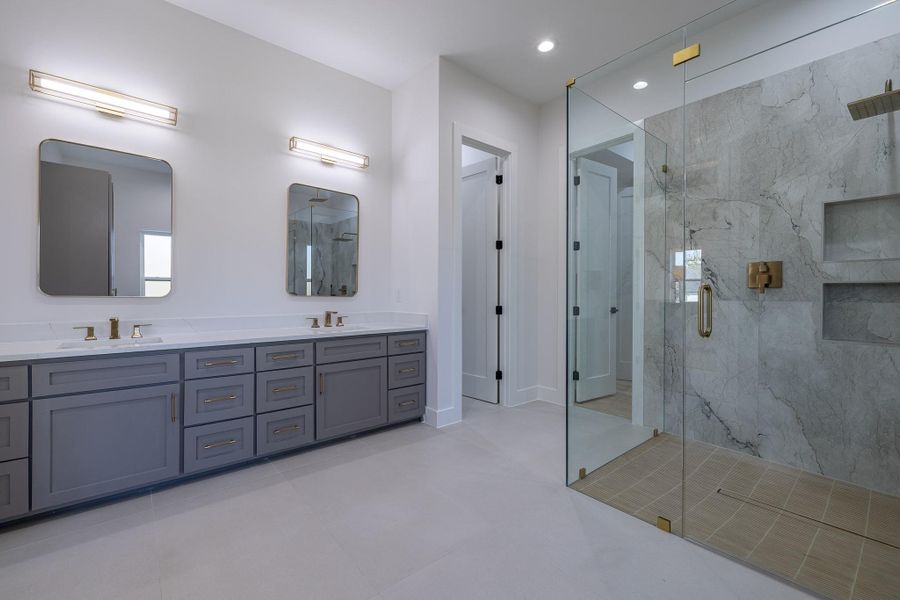 Dual-sink vanity with sleek cabinetry, expansive mirrors, and refined modern styling.