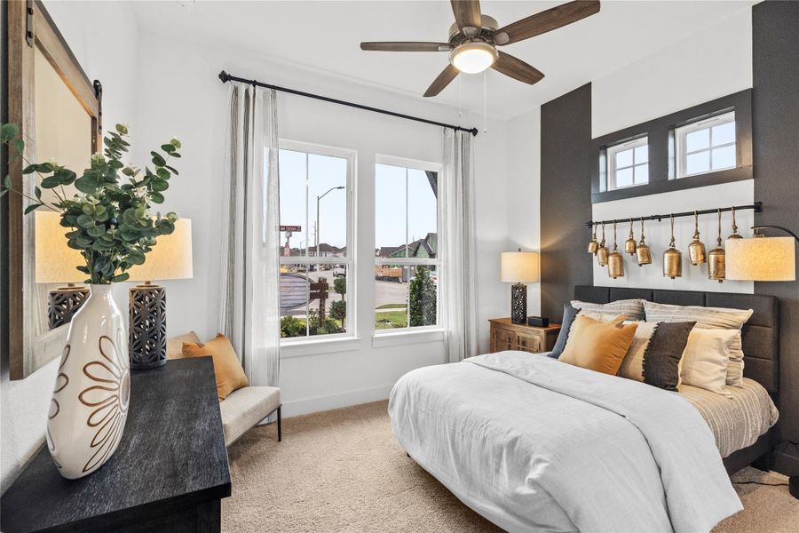 Bedroom featuring carpet flooring, a barn door, and ceiling fan