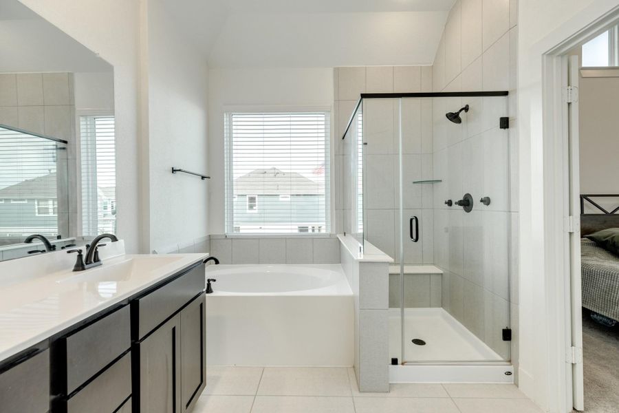 The soaking tub features a window, allowing for ample natural light.