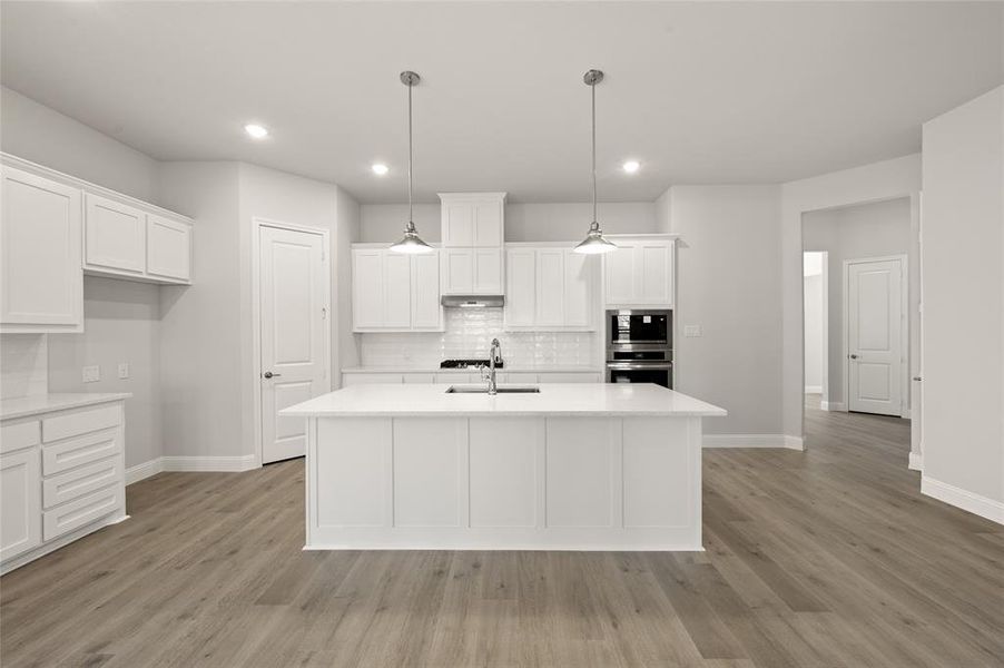 Kitchen featuring oven, baseboards, built in microwave, light countertops, and backsplash Kitchen featuring oven, baseboards, built in microwave, light countertops, and backsplash