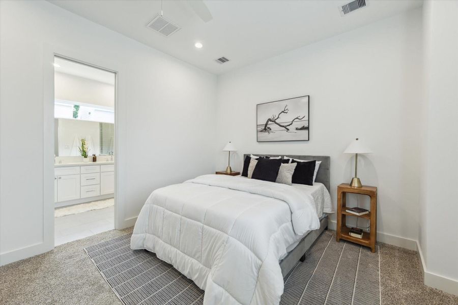 View of the primary bedroom with the primary ensuite bathroom beyond