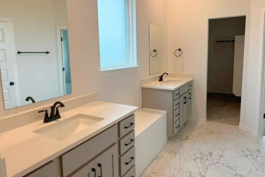 Full bathroom with two vanities and light marble finish floors