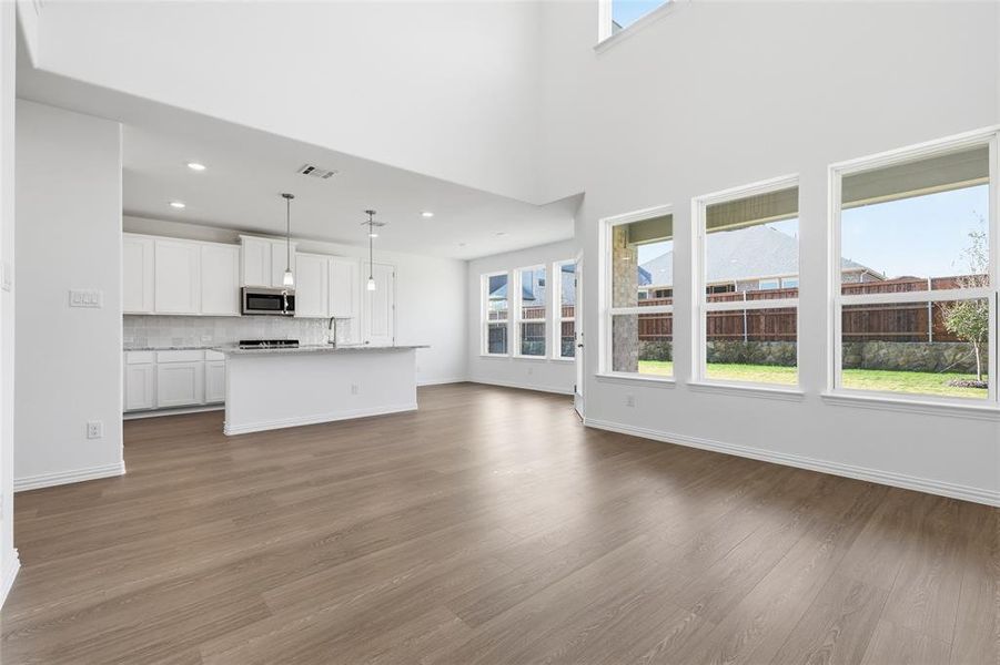 Unfurnished living room featuring dark wood-type flooring and recessed lighting