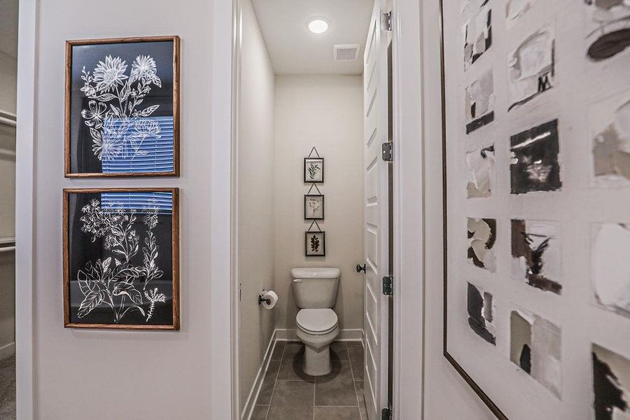 Bathroom with toilet and dark tile patterned floors