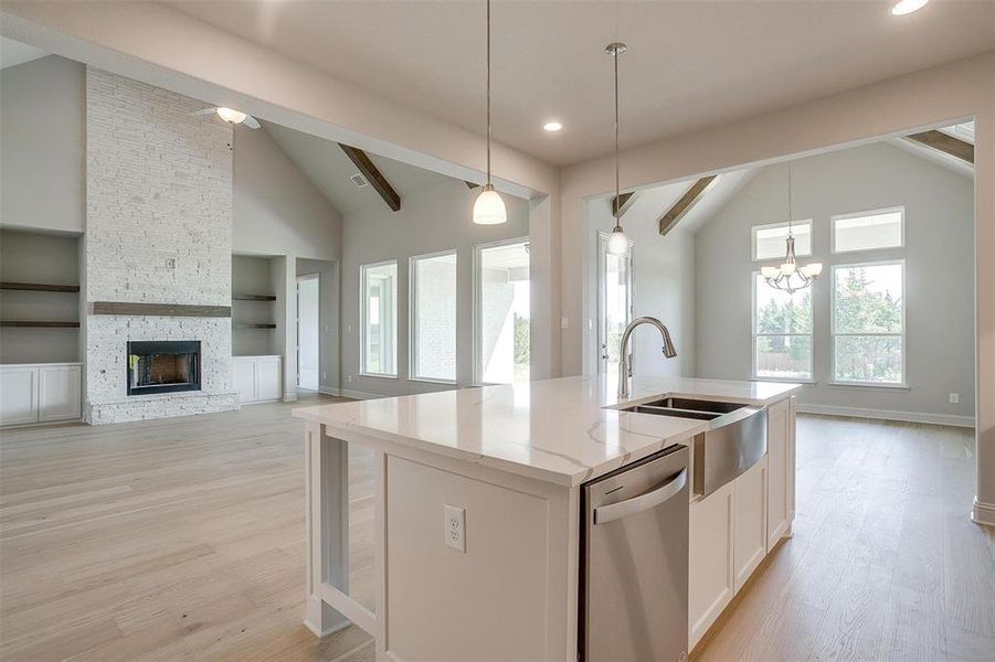 Kitchen featuring built in shelves, stainless steel dishwasher, white cabinetry, light hardwood / wood-style floors, and beamed ceiling